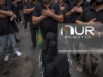 Iranian mourners are beating themselves during a religious festival to commemorate Tasoua, a day ahead of Ashura, while an elderly veiled wo...