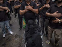 Iranian mourners are beating themselves during a religious festival to commemorate Tasoua, a day ahead of Ashura, while an elderly veiled wo...