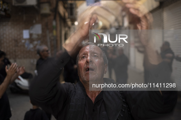 An elderly Iranian mourner is beating himself while participating in a religious festival to commemorate Tasoua, a day ahead of Ashura, in t...