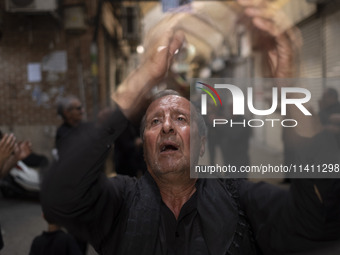 An elderly Iranian mourner is beating himself while participating in a religious festival to commemorate Tasoua, a day ahead of Ashura, in t...