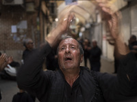 An elderly Iranian mourner is beating himself while participating in a religious festival to commemorate Tasoua, a day ahead of Ashura, in t...