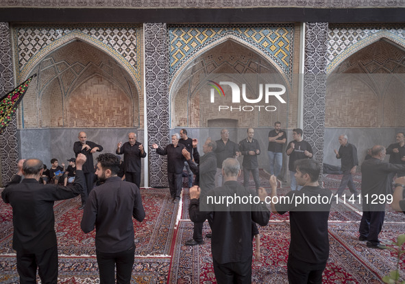 Iranian men are beating themselves while participating in a religious festival to commemorate Tasoua, a day ahead of Ashura, at a mosque in...