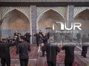 Iranian men are beating themselves while participating in a religious festival to commemorate Tasoua, a day ahead of Ashura, at a mosque in...