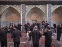 Iranian men are beating themselves while participating in a religious festival to commemorate Tasoua, a day ahead of Ashura, at a mosque in...