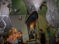 Iranian people are standing next to a religious symbol during a religious festival to commemorate Tasoua, a day ahead of Ashura, in the Gran...