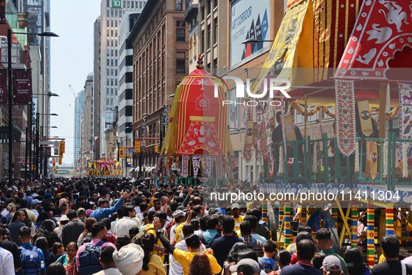 Thousands of Hindu devotees are taking part in the chariot procession as they escort the chariots carrying the deities during the annual Rat...