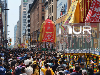 Thousands of Hindu devotees are taking part in the chariot procession as they escort the chariots carrying the deities during the annual Rat...