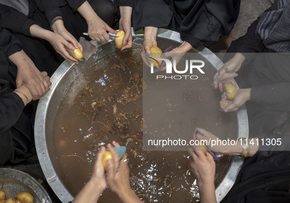 A group of Iranian women are preparing potatoes for use in donated meals during a religious festival to commemorate Tasoua, a day ahead of A...