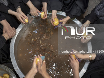 A group of Iranian women are preparing potatoes for use in donated meals during a religious festival to commemorate Tasoua, a day ahead of A...