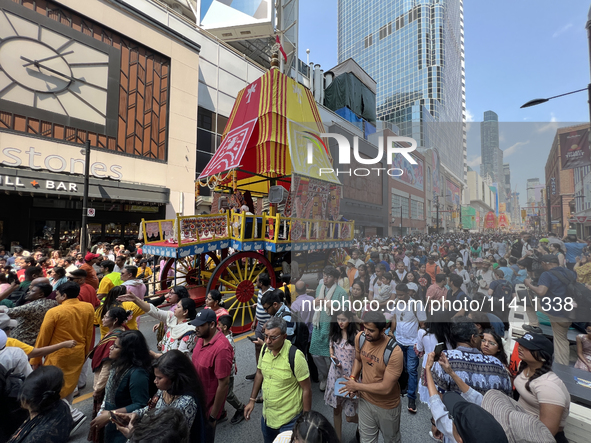 Thousands of Hindu devotees are taking part in the chariot procession as they escort the chariots carrying the deities during the annual Rat...