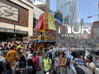 Thousands of Hindu devotees are taking part in the chariot procession as they escort the chariots carrying the deities during the annual Rat...