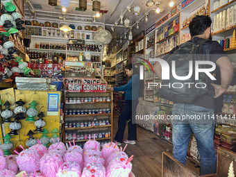 People are shopping for fancy candles at a small shop in Nainital, Uttarakhand, India, on April 21, 2024. (