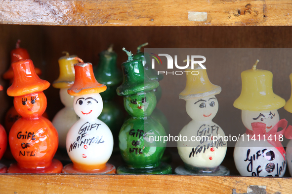 Fancy candles in the shape of snowmen are being displayed at a small shop in Nainital, Uttarakhand, India, on April 21, 2024. 