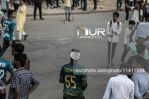 An unidentified student is being seen with a head bandage as he is injured during a clash between BCL members and Quota Student Protesters i...