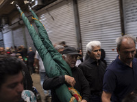 An Iranian man is carrying a religious flag while walking along a bazaar during a religious festival to commemorate Tasoua, a day ahead of A...