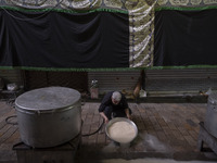 An Iranian man is preparing donated meals during a religious festival to commemorate Tasoua, a day ahead of Ashura, in the Grand Bazaar, in...