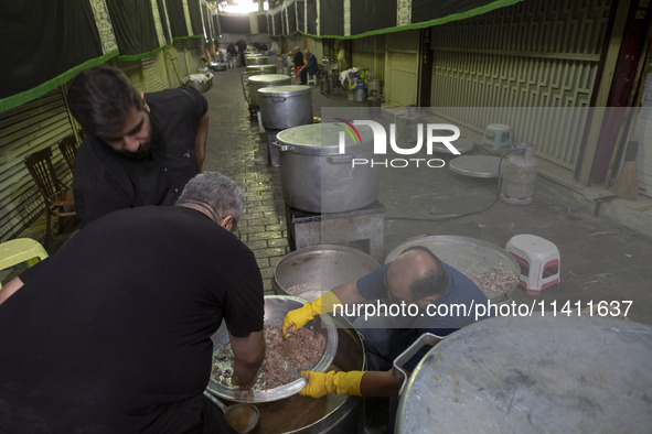 Iranian men are preparing donated meals during a religious festival to commemorate Tasoua, a day ahead of Ashura, in the Grand Bazaar, in so...