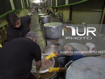 Iranian men are preparing donated meals during a religious festival to commemorate Tasoua, a day ahead of Ashura, in the Grand Bazaar, in so...