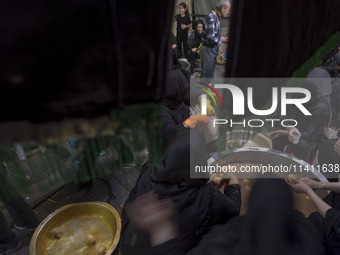 Iranian women are preparing donated meals during a religious festival to commemorate Tasoua, a day ahead of Ashura, in the Grand Bazaar, in...