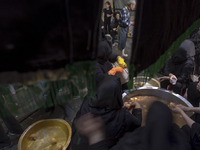 Iranian women are preparing donated meals during a religious festival to commemorate Tasoua, a day ahead of Ashura, in the Grand Bazaar, in...