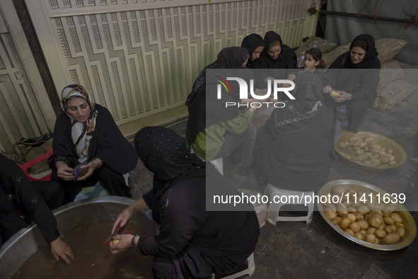 Iranian women are preparing donated meals during a religious festival to commemorate Tasoua, a day ahead of Ashura, in the Grand Bazaar, in...