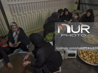 Iranian women are preparing donated meals during a religious festival to commemorate Tasoua, a day ahead of Ashura, in the Grand Bazaar, in...