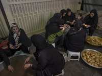 Iranian women are preparing donated meals during a religious festival to commemorate Tasoua, a day ahead of Ashura, in the Grand Bazaar, in...