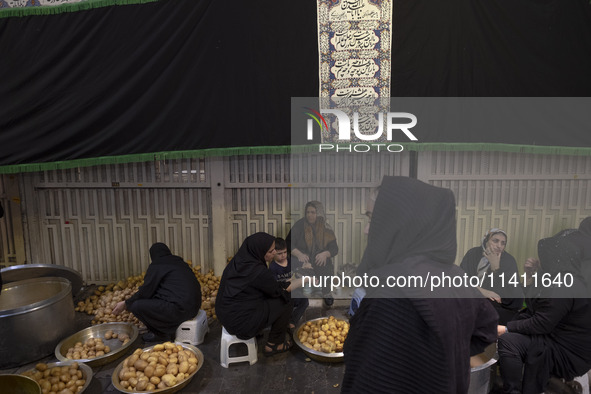 Iranian women are preparing donated meals during a religious festival to commemorate Tasoua, a day ahead of Ashura, in the Grand Bazaar, in...