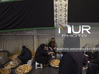 Iranian women are preparing donated meals during a religious festival to commemorate Tasoua, a day ahead of Ashura, in the Grand Bazaar, in...