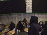 Iranian women are preparing donated meals during a religious festival to commemorate Tasoua, a day ahead of Ashura, in the Grand Bazaar, in...