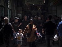 An Iranian woman and her young son are walking along a bazaar while participating in a religious festival to commemorate Tasoua, a day ahead...