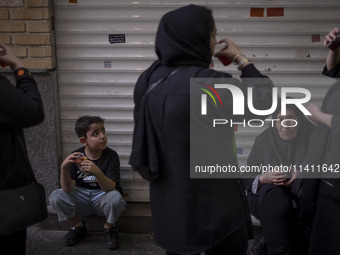 An Iranian family is drinking and eating donated tea and sweets while participating in a religious festival to commemorate Tasoua, a day ahe...