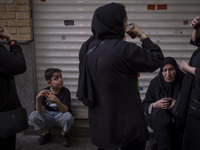 An Iranian family is drinking and eating donated tea and sweets while participating in a religious festival to commemorate Tasoua, a day ahe...