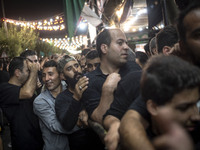 Iranian men are standing in line while waiting to receive donated meals during a religious rally to commemorate Tasoua, in Dolatabad neighbo...