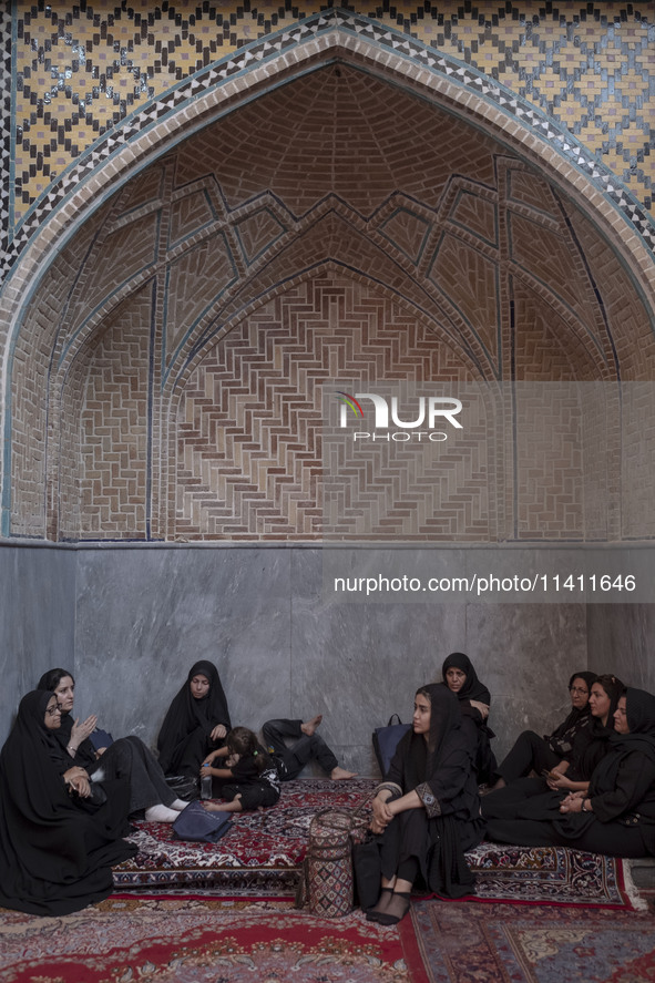 A group of young Iranian women are sitting together at a mosque during a religious festival to commemorate Tasoua, a day ahead of Ashura, in...