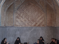 A group of young Iranian women are sitting together at a mosque during a religious festival to commemorate Tasoua, a day ahead of Ashura, in...