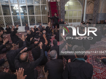 Iranian mourners are beating themselves while participating in a religious festival to commemorate Tasoua, a day ahead of Ashura, at a mosqu...