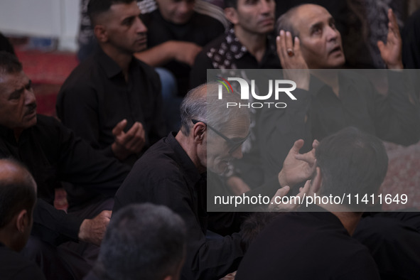 Iranian mourners are praying while participating in a religious festival to commemorate Tasoua, a day ahead of Ashura, at a mosque in the Gr...