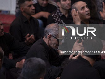 Iranian mourners are praying while participating in a religious festival to commemorate Tasoua, a day ahead of Ashura, at a mosque in the Gr...