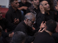 Iranian mourners are praying while participating in a religious festival to commemorate Tasoua, a day ahead of Ashura, at a mosque in the Gr...