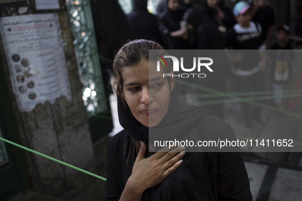 A young Iranian woman is beating herself while participating in a religious festival to commemorate Tasoua, a day ahead of Ashura, in the Gr...