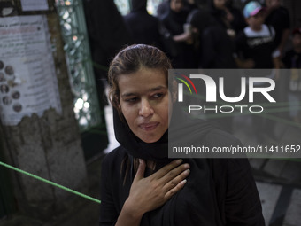 A young Iranian woman is beating herself while participating in a religious festival to commemorate Tasoua, a day ahead of Ashura, in the Gr...