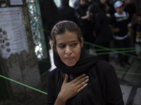 A young Iranian woman is beating herself while participating in a religious festival to commemorate Tasoua, a day ahead of Ashura, in the Gr...