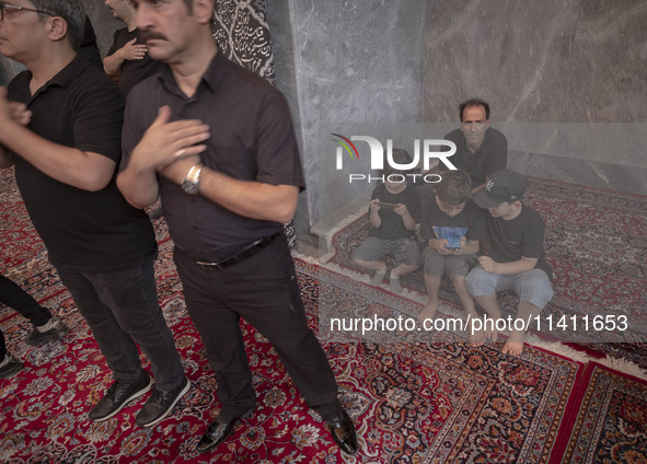 Iranian mourners are beating themselves while participating in a religious festival to commemorate Tasoua, a day ahead of Ashura, at a mosqu...