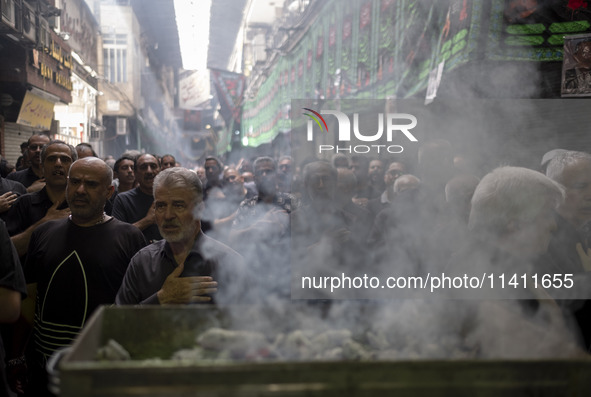 Iranian mourners are beating themselves while participating in a religious festival to commemorate Tasoua, a day ahead of Ashura, in the Gra...