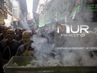 Iranian mourners are beating themselves while participating in a religious festival to commemorate Tasoua, a day ahead of Ashura, in the Gra...