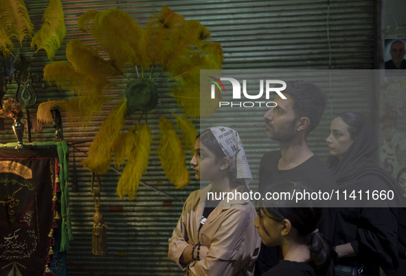 An Iranian family is participating in a religious festival to commemorate Tasoua, a day ahead of Ashura, in the Grand Bazaar, in southern Te...