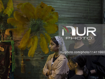 An Iranian family is participating in a religious festival to commemorate Tasoua, a day ahead of Ashura, in the Grand Bazaar, in southern Te...