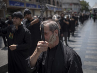 An Iranian mourner is beating himself with a chain during a religious festival to commemorate Tasoua, a day ahead of Ashura, in the Grand Ba...