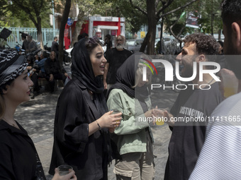 Iranian youths are standing together outside the Grand Bazaar (Market), during a religious festival to commemorate Tasoua, a day ahead of As...